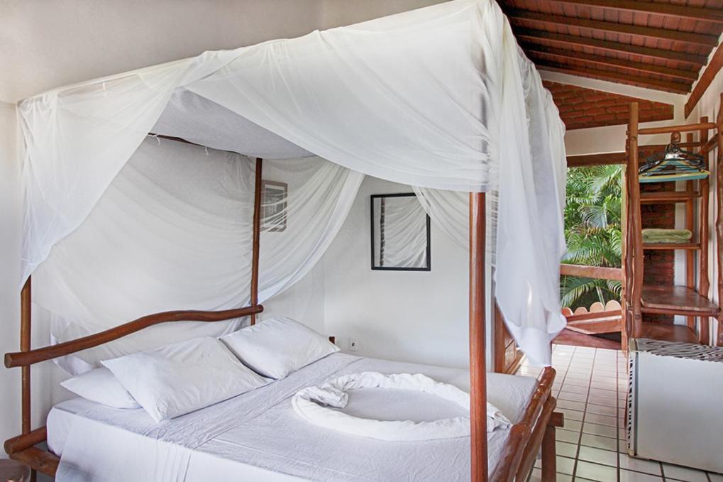 Novos Baianos Hostel E Pousada Порту-Сегуру Экстерьер фото A mosquito net over a bed