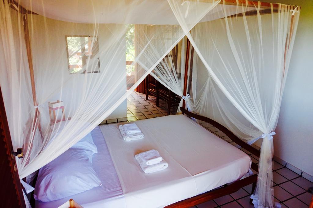 Novos Baianos Hostel E Pousada Порту-Сегуру Экстерьер фото A mosquito net over a bed